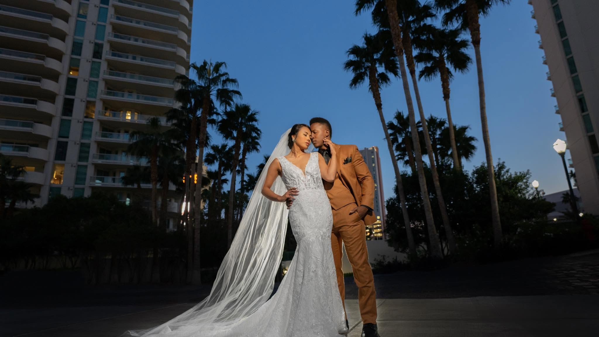 A couple photographed among the palms at Turnberry Place at dusk
