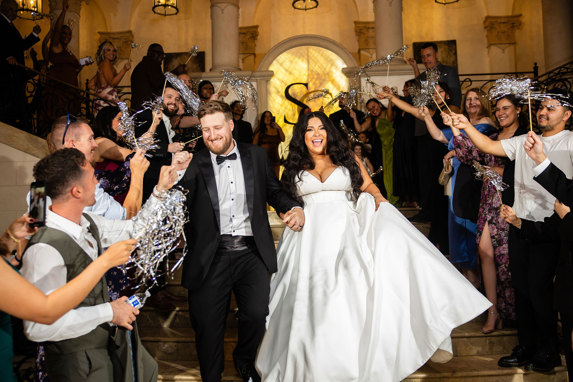 Newlyweds walking through a joyful grand exit at The Stirling Club